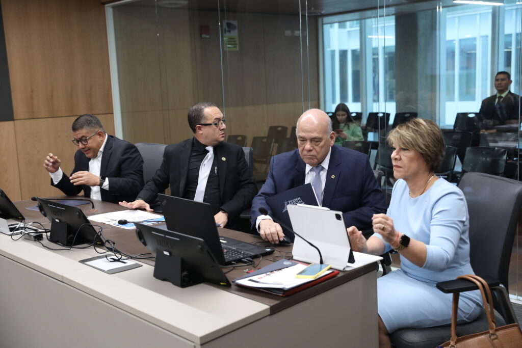 Un grupo de personas sentadas frente a una mesa con una computadora
Descripción generada automáticamente con confianza media